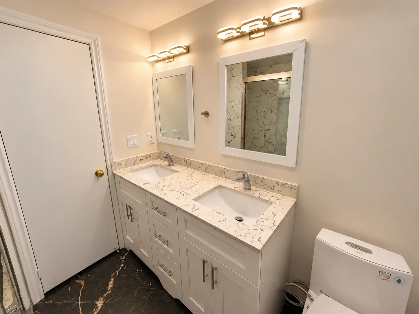 Space to start the day: A double vanity, twin mirrors and marble-look counters create a practical shared bathroom.