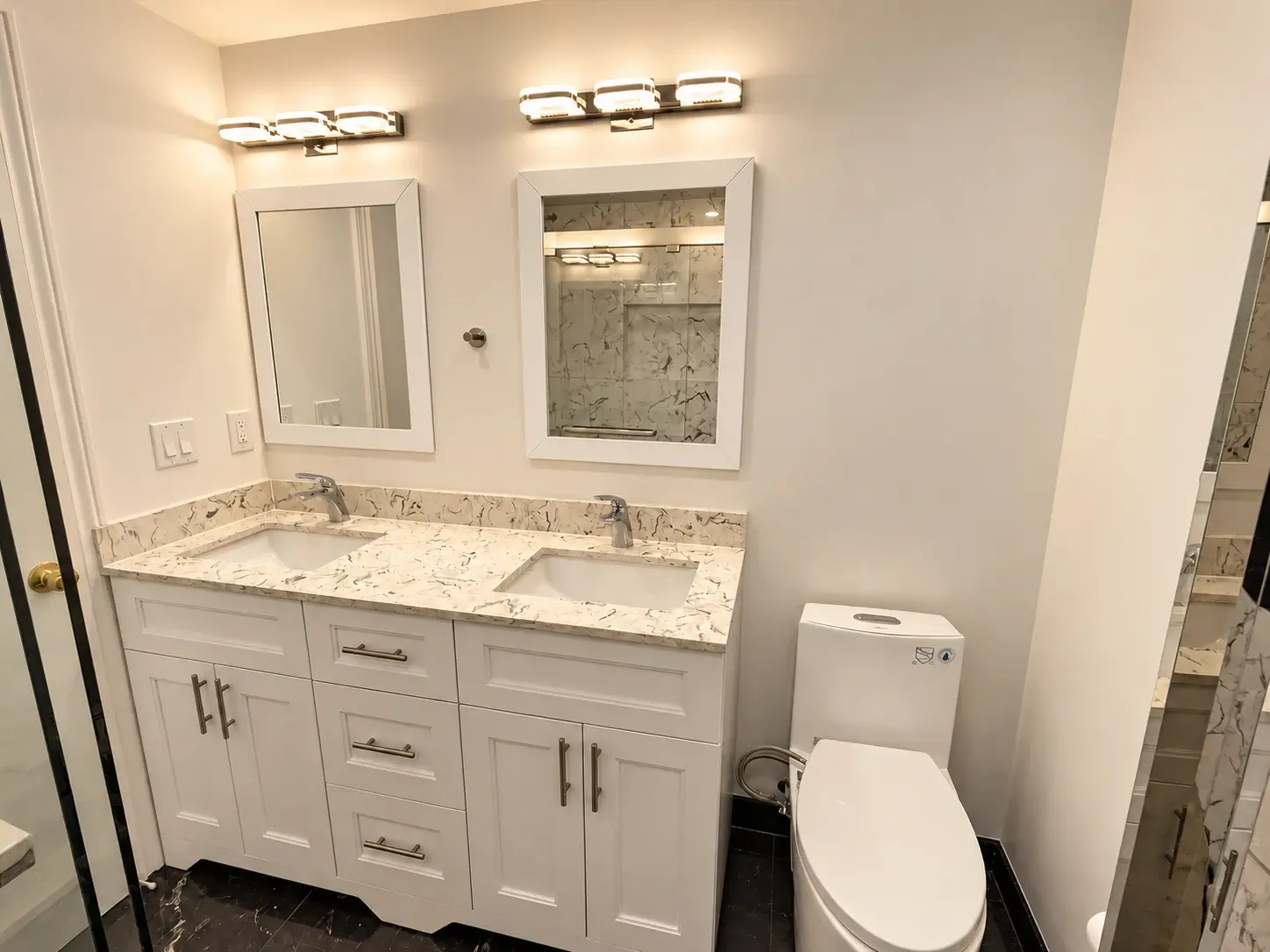 Space to start the day: A double vanity, twin mirrors and marble-look counters create a practical shared bathroom.