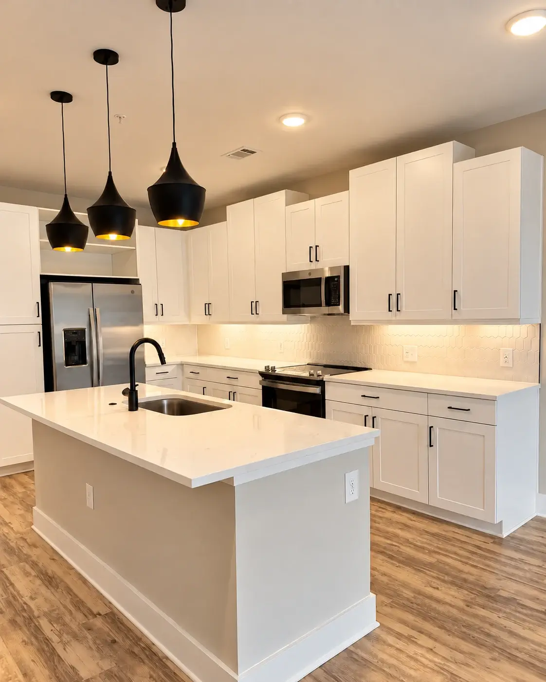 Light at the heart of the home: Dark pendant lights and a black faucet contrast with a bright white kitchen and island.