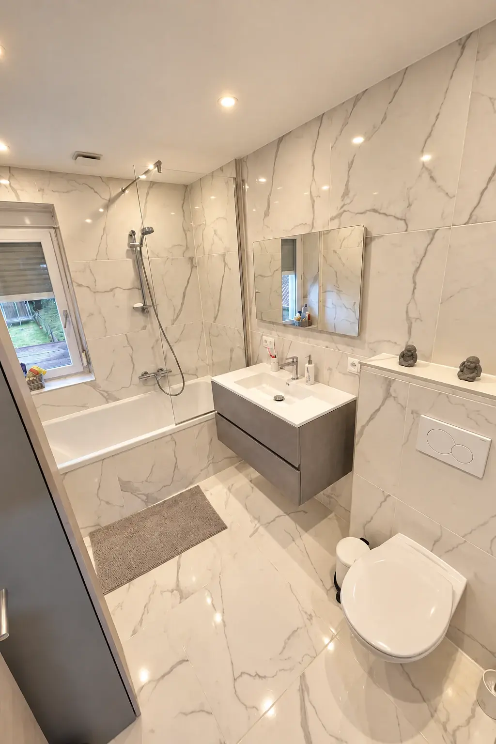 Refined in every detail: A wall-hung vanity, rectangular mirror and glass bath screen keep this tiled bathroom feeling open.